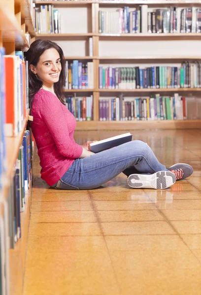 Студент читає книгу в бібліотеці — стокове фото