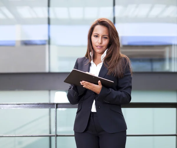 Lachende jonge zakenvrouw met behulp van zijn digitale Tablet PC op kantoor — Stockfoto