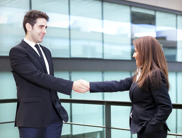 Business partners shaking hands in meeting hall — Stock Photo, Image