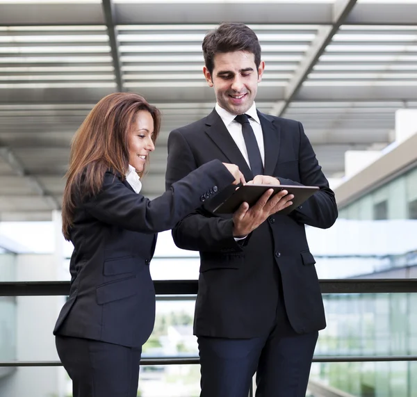 Smiling business partners working with electronic tablet at mode — Stock Photo, Image