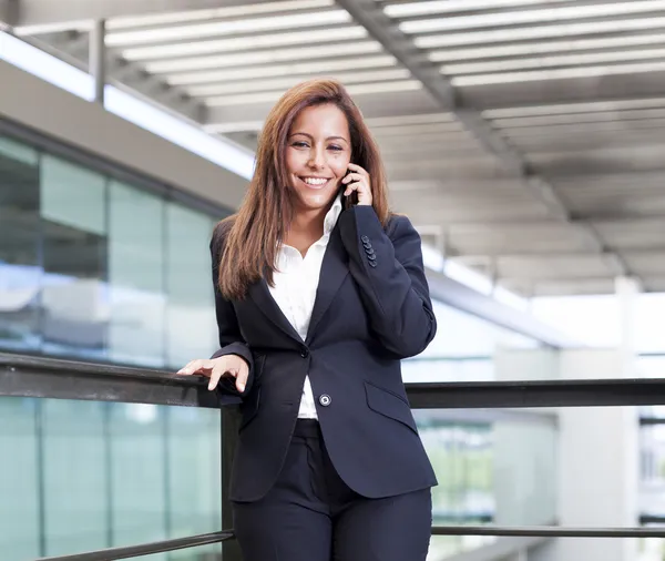 Young business woman talking on cell phone at the office — Stock Photo, Image