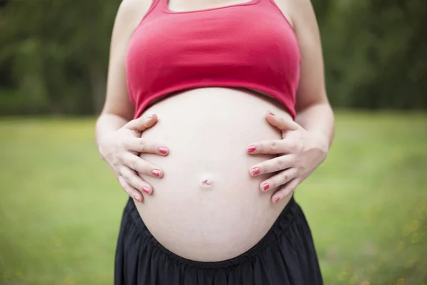 Těhotná žena dotýká břicho — Stock fotografie