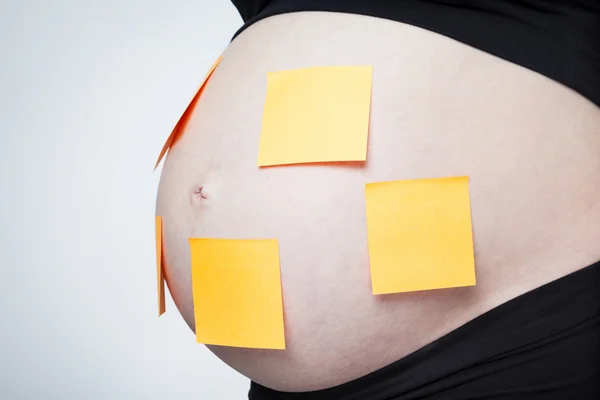 Pregnant belly with yellow sticks Royalty Free Stock Photos