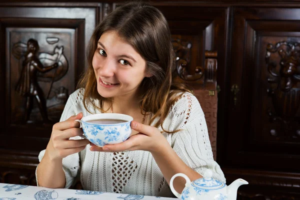 Mujer joven y bonita sentada con una taza de té —  Fotos de Stock