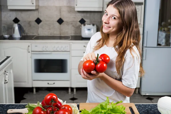 Young woman with tomato showing bunch of tomatoes — Stock Photo, Image