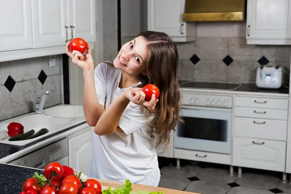 Young woman playing with tomatos. — Stock Photo, Image