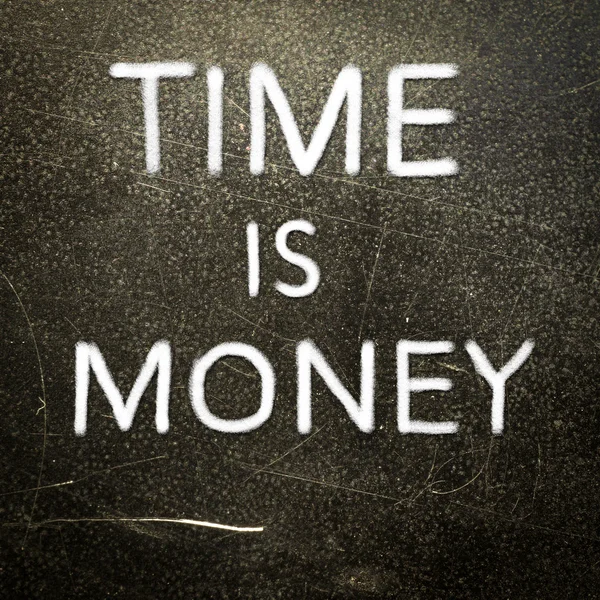 Tijd is geld handgeschreven met wit krijt op een donkere achtergrond — Stockfoto