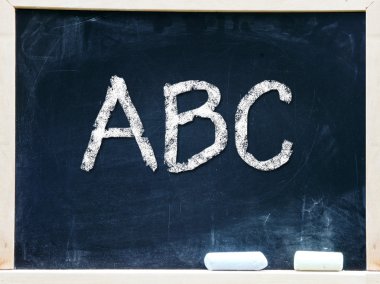 bir kara tahta üzerinde el yazısı abc tebeşir