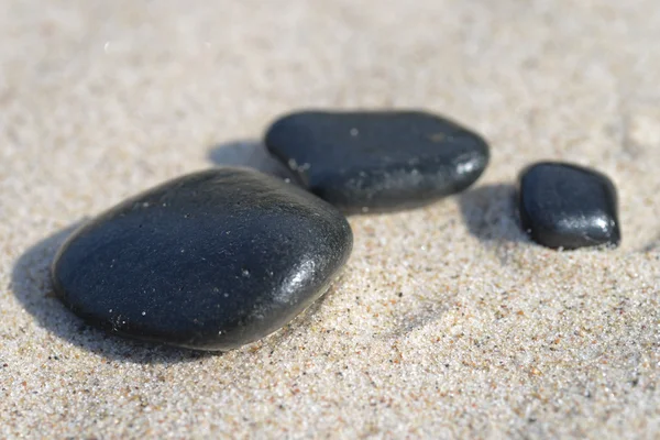 Batu hitam di pasir — Stok Foto