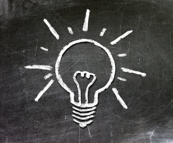 Light bulb on blackboard background — Stock Photo, Image