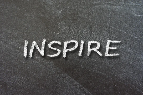 Inspire handwritten with white chalk — Stock Photo, Image