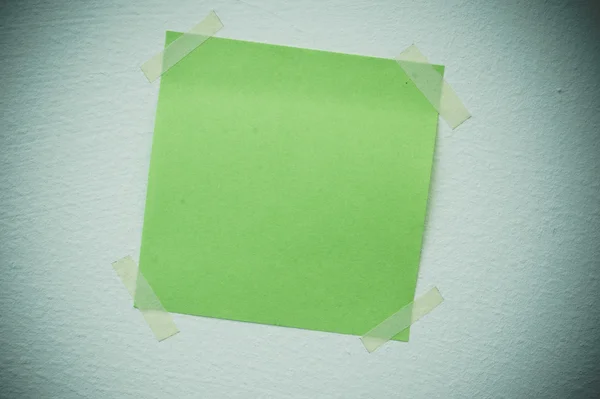 A blank sticky note with a notebook on the wall — Stock Photo, Image