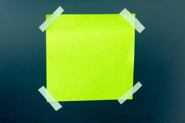 A blank sticky note with a notebook on the wall — Stock Photo, Image