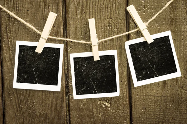 Photo paper attach to rope with clothes pins on wooden background — Stock Photo, Image