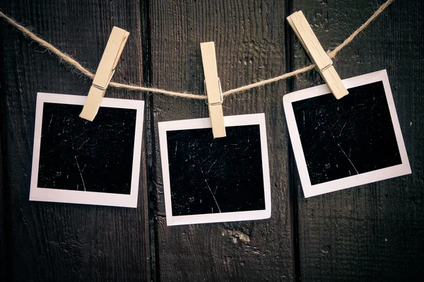 Papier photo attaché à la corde avec des épingles à linge sur fond en bois — Photo