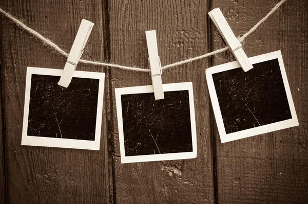 Fotopapier hechten aan touw met kleren pinnen op houten achtergrond — Stockfoto