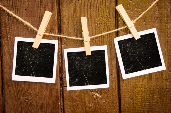 Fotopapier hechten aan touw met kleren pinnen op houten achtergrond — Stockfoto