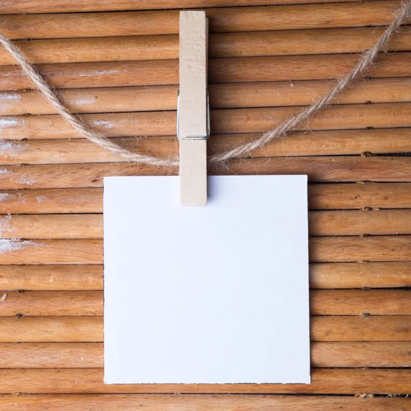 Note and a clothes peg on wood background — Stock Photo, Image