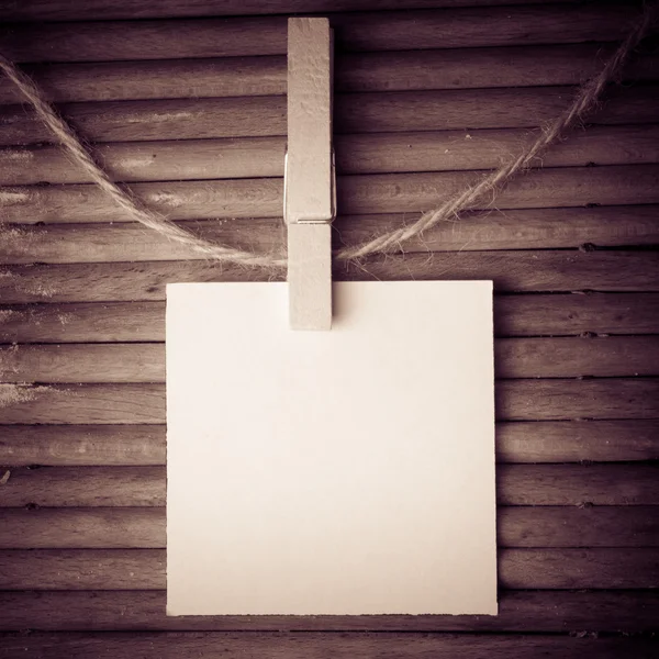 Note and a clothes peg on wood background — Stock Photo, Image