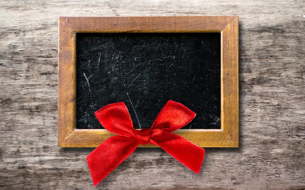 Wooden frame with a red bow — Stock Photo, Image