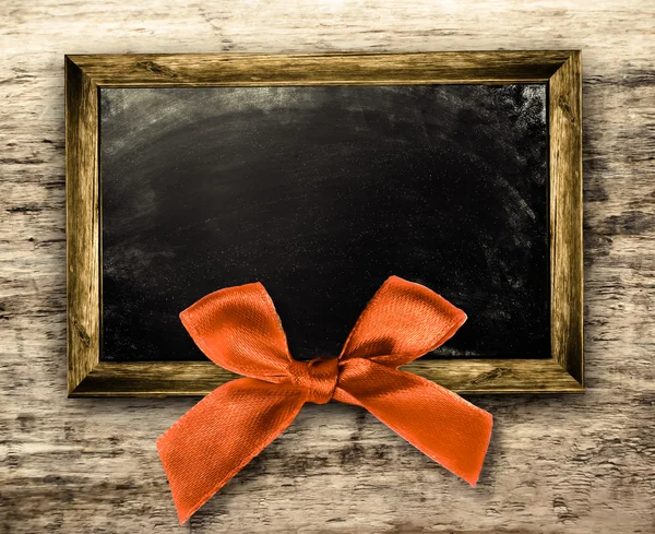 Wooden frame with a red bow — Stock Photo, Image