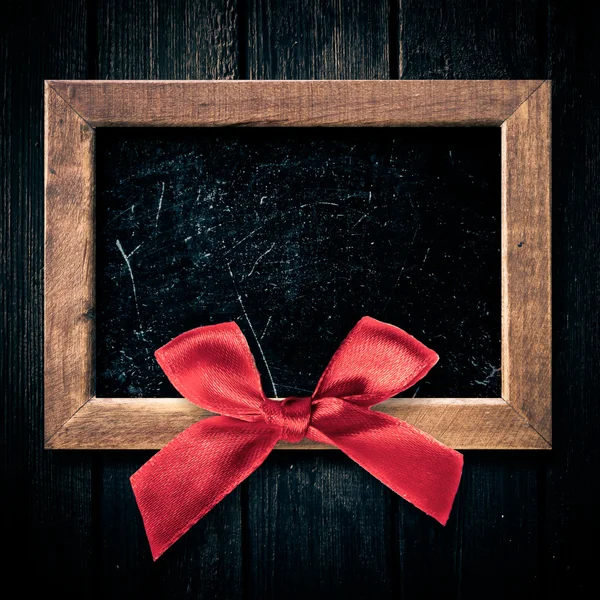 Деревянная рамка с красным бантом — стоковое фото
