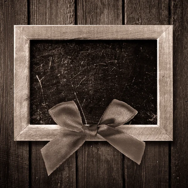 Wooden frame with a red bow — Stock Photo, Image