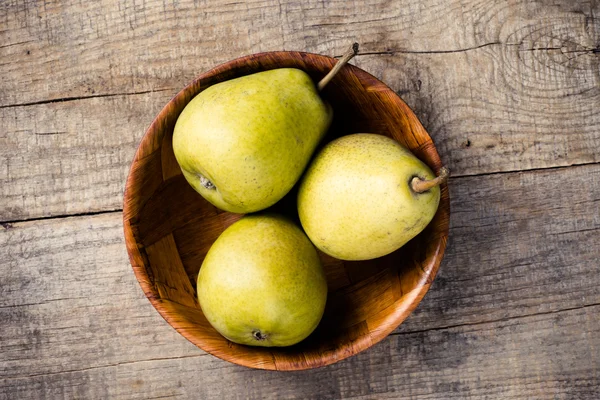 Färska päron i en trä skål — Stockfoto