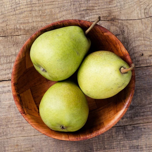 Färska päron i en trä skål — Stockfoto