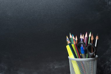 Tahtanın önünde kalemler fincanda.