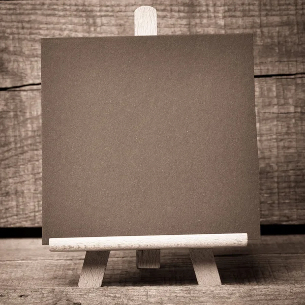 Pequeno quadro preto emoldurado de madeira no fundo de madeira — Fotografia de Stock