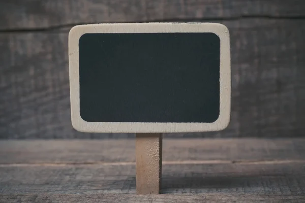 Small wooden framed blackboard on wooden background — Stock Photo, Image