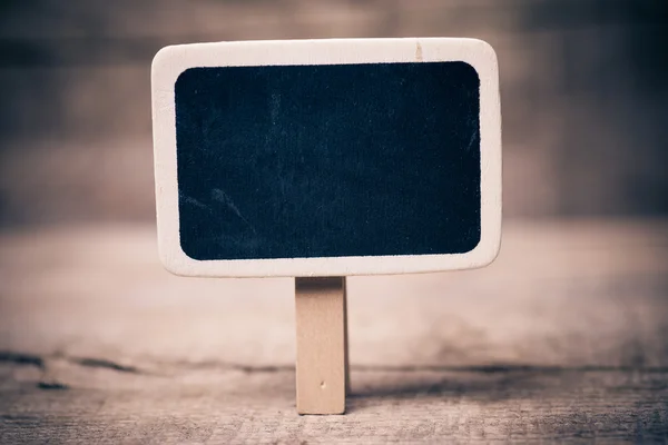 Small wooden framed blackboard on wooden background — Stock Photo, Image