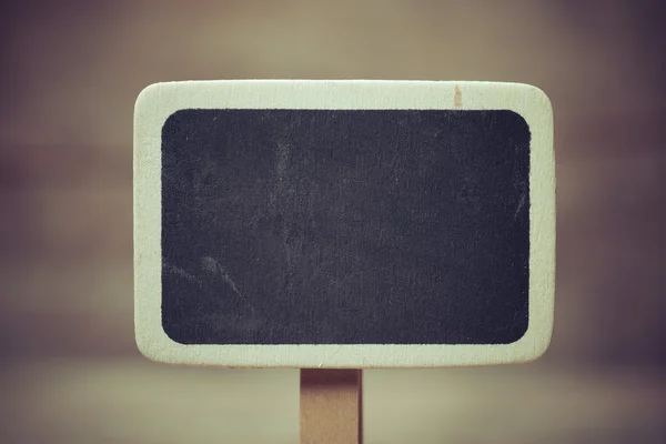 Small wooden framed blackboard on wooden background — Stock Photo, Image