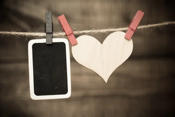 Foto y corazón colgando en el tendedero — Foto de Stock