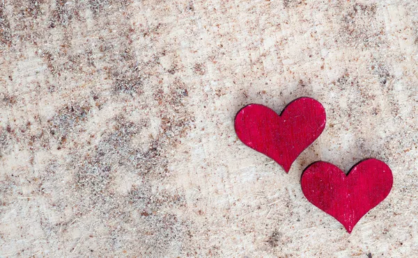 Två röda hjärtan på sand — Stockfoto
