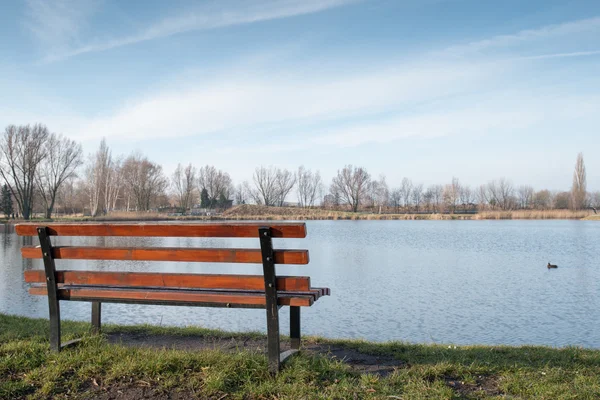 湖の近くの孤独なベンチ — ストック写真