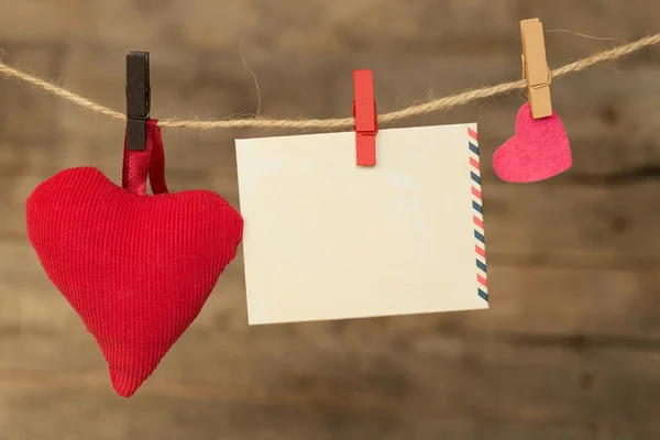 Hoja de papel instantánea en blanco y corazón colgando en el tendedero — Foto de Stock