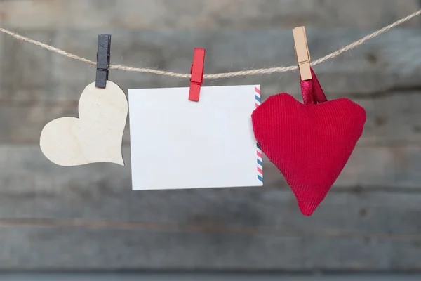 Hoja de papel instantánea en blanco y corazón colgando en el tendedero — Foto de Stock