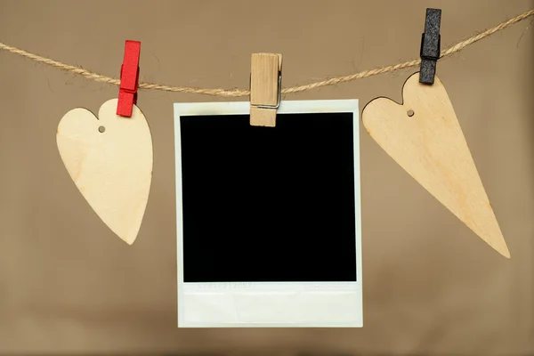 Blank instant photo and heart hanging on the clothesline — Stock Photo, Image