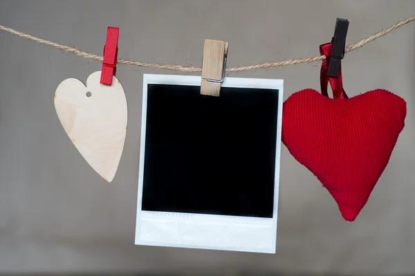 Blank instant photo and heart hanging on the clothesline — Stock Photo, Image