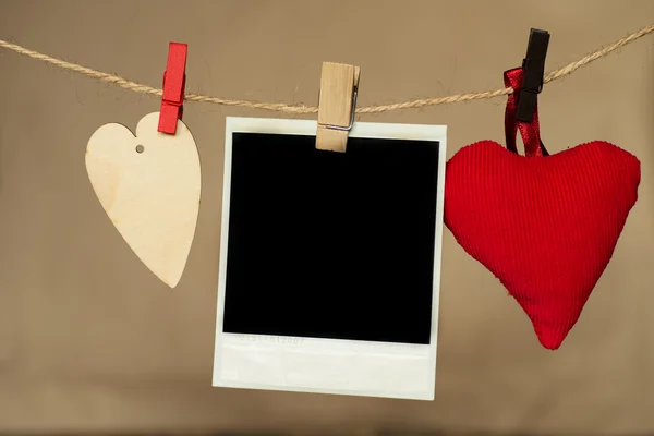 Foto instantánea en blanco y corazón colgando en el tendedero — Foto de Stock