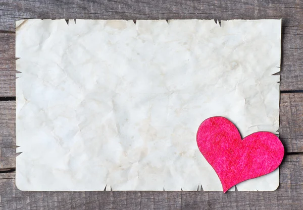 Wooden heart on old paper — Stock Photo, Image