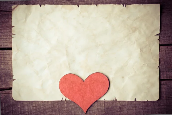 Wooden heart on old paper Stock Image