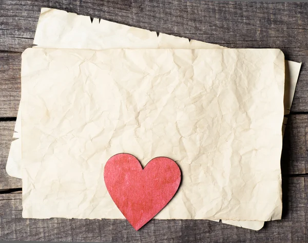 Corazón de madera sobre papel viejo — Foto de Stock