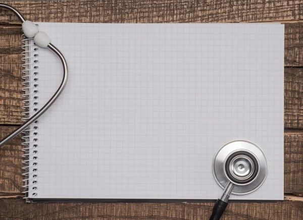 A blank and stethoscope on a desktop — Stock Photo, Image