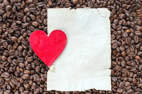 Kaffebönor med hjärta på pappers-täcker — Stockfoto