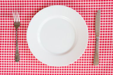 çatal bıçak ve plaka üzerinde kırmızı masa örtüsü