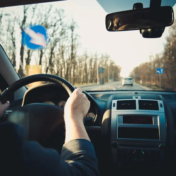 Mãos do condutor no volante — Fotografia de Stock