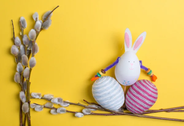 Huevos de Pascua, conejo y amentos sobre un fondo de madera — Foto de Stock